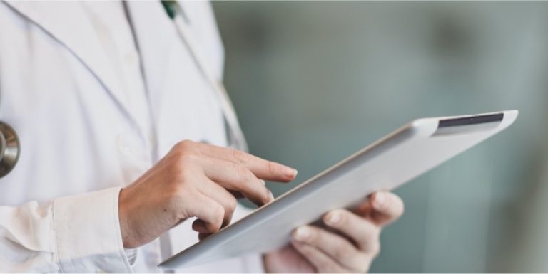 Medical professional using a digital tablet, representing healthcare IT services or electronic data management.
