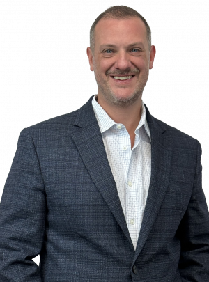 Professional man in a blue plaid blazer and light shirt, smiling confidently against a transparent background, waist up